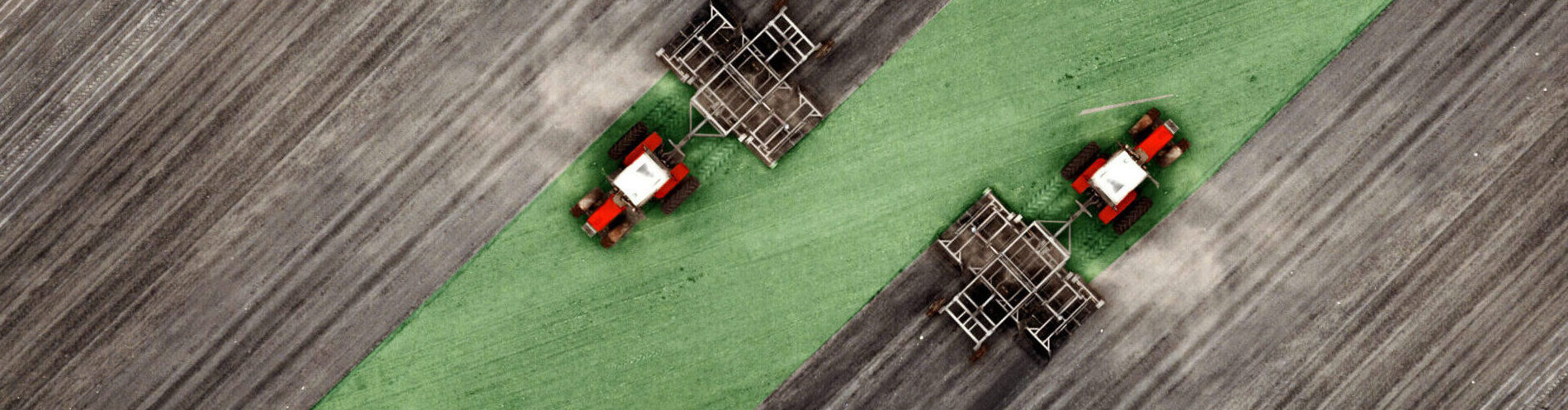 Aerial top view of a tractor, combine harvester plowing agricultural land in the spring